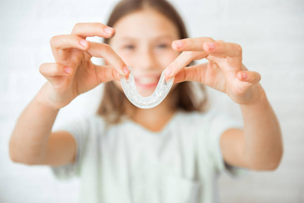 lächelndes mädchen mit gesunden zähnen mit herausnehmbaren zahnspangen oder aligner zum begradigen und aufhellen der zähne. kieferorthopädische behandlung zur bisskorrektur - teenager dentist patient cheerful stock-fotos und bilder
