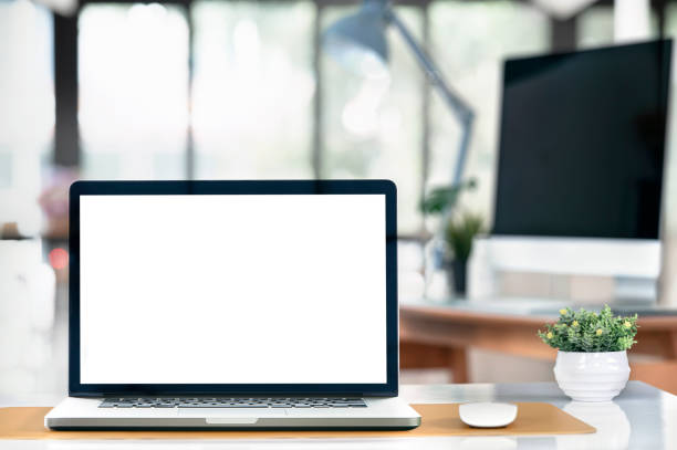 istock Mockup blank white screen laptop computer on the table in office room. 1360190995