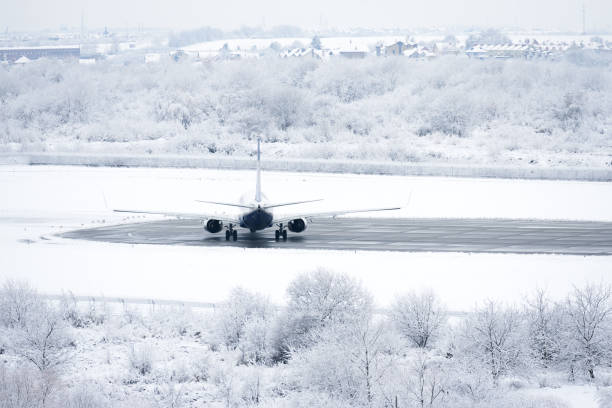 istock Airplane is getting ready for flight. Airliner on runway in blizzard. 1360191605