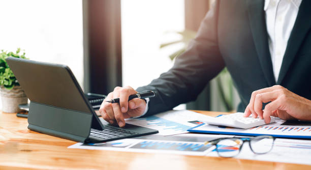 istock businessman working at office with document on his desk, doing planning analyzing the financial report, business plan investment, finance analysis concept.Using calculator and tablet. 1360195499
