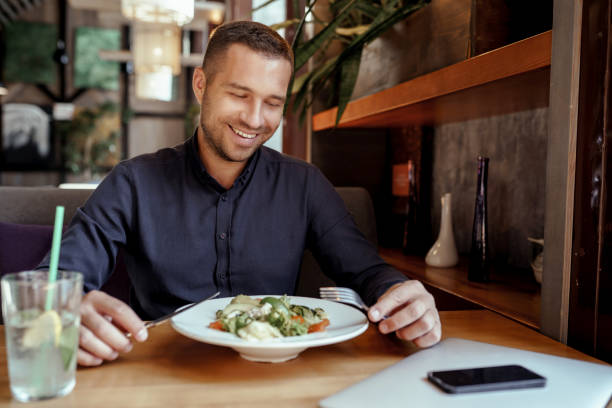 istock Smiling businessman is having lunch in restaurant 1360195524