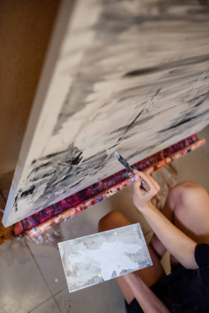 istock painter hand holding a brush and paint an abstract picture 1360196949