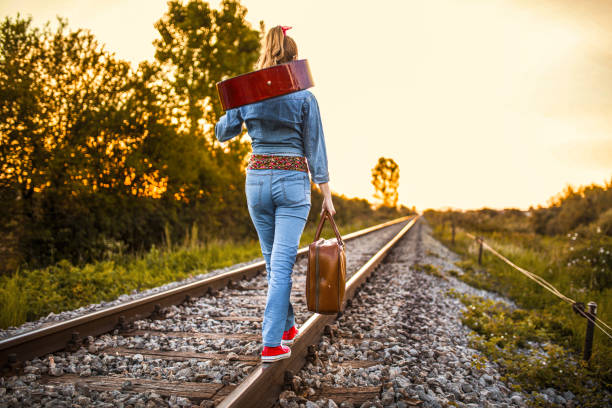 istock Woman walking on the railroad track 1360197532