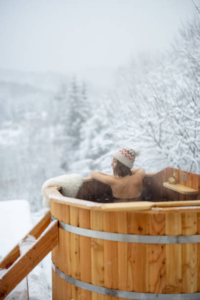 istock Woman relaxing in hot bath at snowy mountains 1360197601