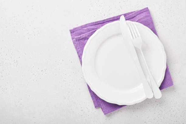 istock Christmas table setting white color with silverware, napkin trendy color very peri in 2022 Year, Christmas balls, stars, champagne, glasses on white background for xmas greetings. Mock up. 1360197911