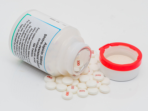 A pill bottle with 300mg Aspirin tablets spilling out