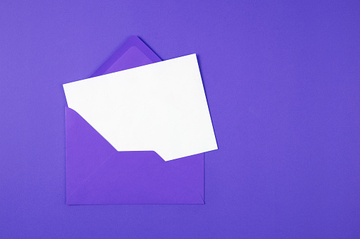 Purple envelope containing white empty paper on blue background