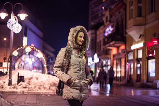 Beautiful woman walking through the city on a cold winter night