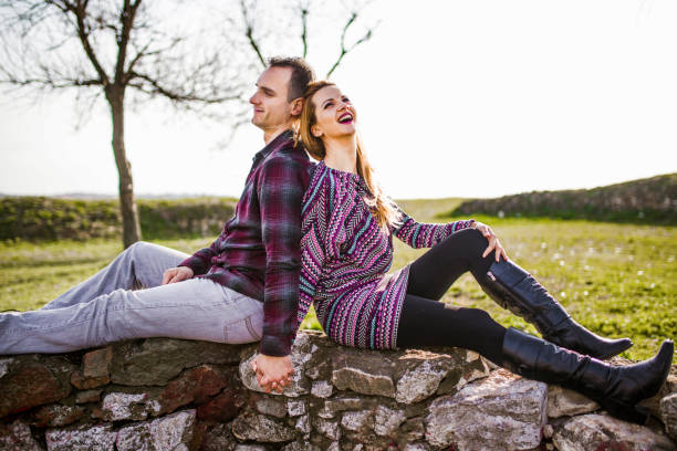 Young romantic couple sitting in the park holding hands