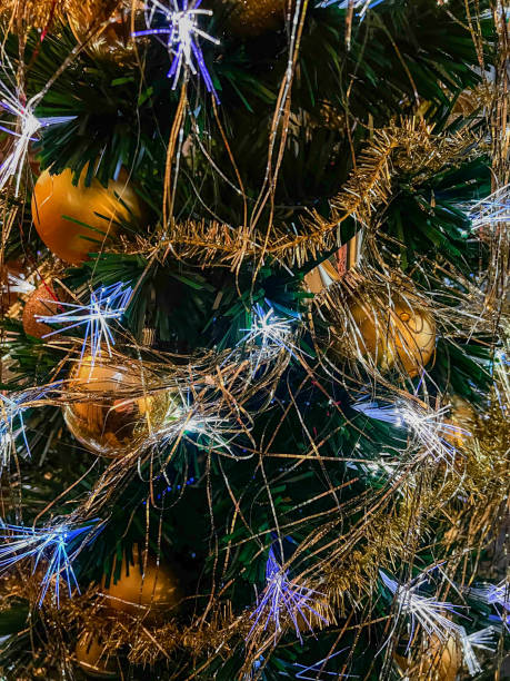 istock Decorated branches of a Christmas tree with golden balls, light and glitter. 1360200272