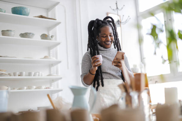 istock Female pottery artist using smartphone in her art studio 1360200289
