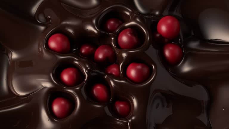 Sour cherries falling into dark chocolate