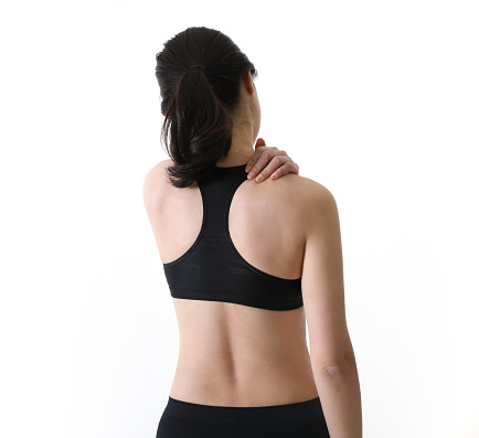 Back view of a woman holding a painful back neck and back