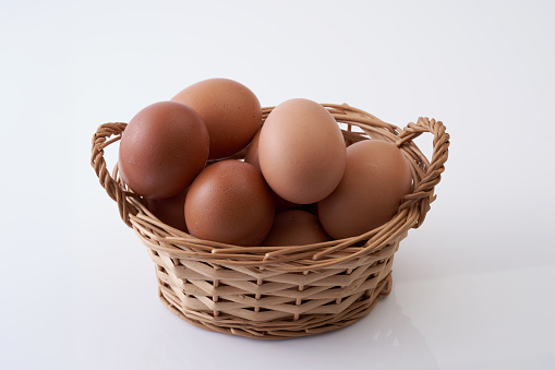 basket of eggs on white background