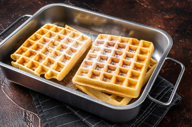 istock Viennese waffles with powdered sugar in kitchen steel tray. Dark background. Top view 1360209819