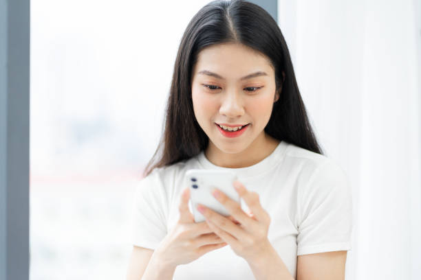 istock image of girl using phone next to window 1360211049