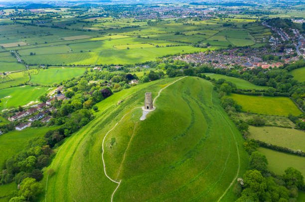 glastonbury tor filmato dal drone nella giornata di sole, monumento iconico in mezzo alla campagna - somerset levels foto e immagini stock
