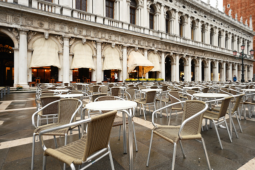 Venice, Italy - November 03, 2021: Empty tables in front of a cafe at San Marco square in Venice, Italy