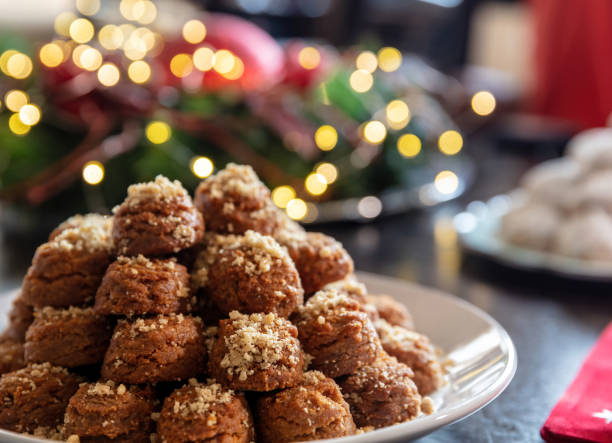 Christmas Greek dessert. Traditional homemade melomakarona in a plate closeup view Christmas Greek desserts. Traditional homemade melomakarona plate, bokeh Xmas lights decoration background, closeup view walnut cookies stock pictures, royalty-free photos & images