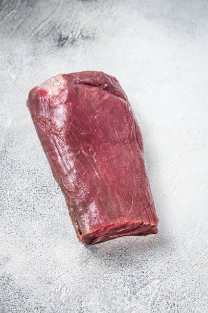 istock Beef Tenderloin raw meat on butcher table. White background. Top view 1360214875