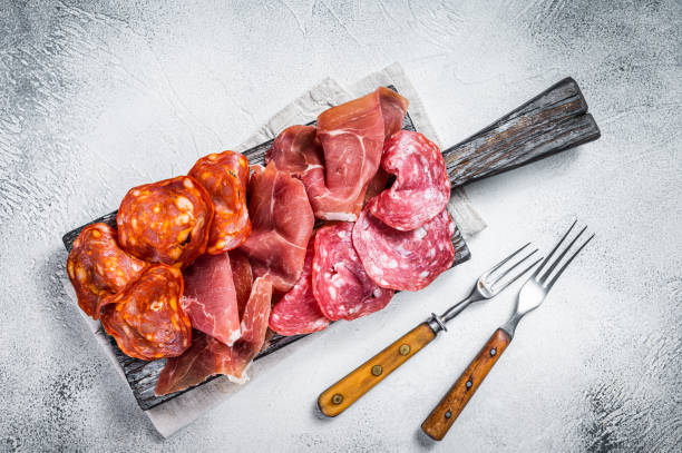 antipasti di carne assortiti - salame, jamon, salsicce choriso. sfondo bianco. visualizzazione dall'alto - prodotto a base di carne foto e immagini stock