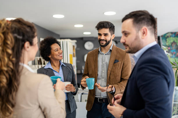istock Four coworkers taking a coffee break at the office 1360216345