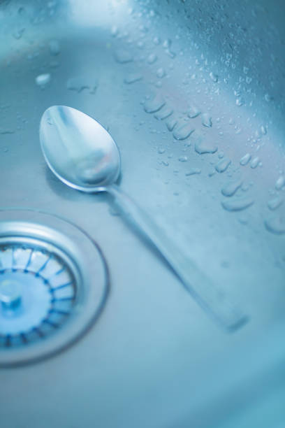 Steel spoon in a wet steel sink