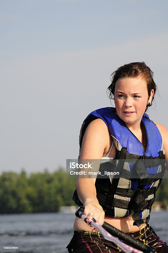 Młoda kobieta mokry od lake wygląda intense wakeboarding. - Zbiór zdjęć royalty-free (20-24 lata)