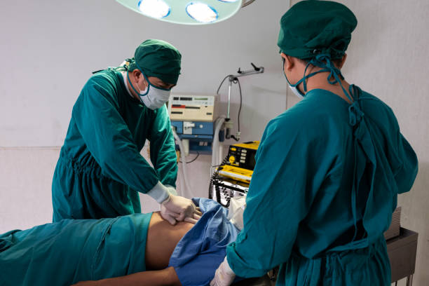 istock Selective focus at defibrillator while doctor use it to pump at chest of unconscious with low heart rate patient to save life while doing medical surgery inside of operating room. Emergency aid, CPR. 1360218542
