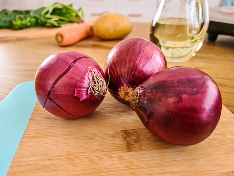 A close-up of onions on a cutting board in the kitchen.