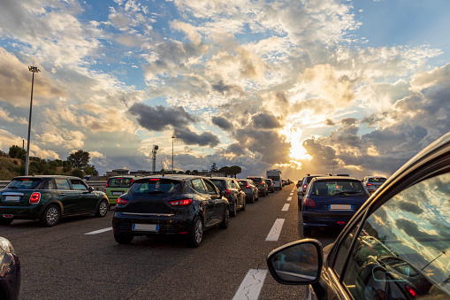 Cars lined up on an Italian highway at sunset. Highway traffic jam.