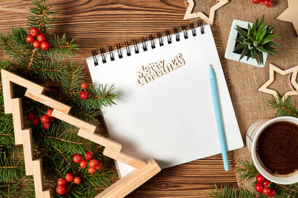 istock Christmas composition of open blank notepad, coffee cup, Christmas tree and Cactus on wooden background 1360222314