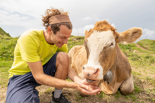 Happy friendship,  cattle cow beside him\nAppenzelerland canton, Switzerland