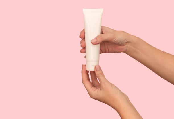 istock Hand holds a white container with cosmetic cream. For body care. 1360223292