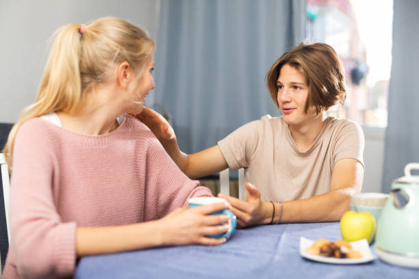 istock Smiling teenager chatting with mom while drinking tea at home 1360223413