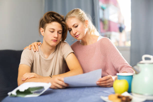 istock Unhappy mother and son reading letter from school 1360223431