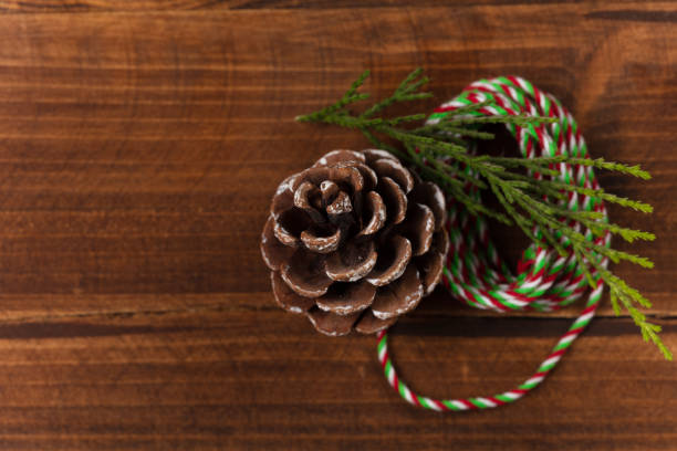 Christmas gift, christmas concept with christmas tree branches and pinecone on wooden background.