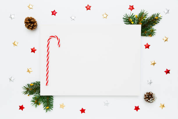 istock Christmas, New Year holiday layout with copy space for text. Blank white paper with candy cane, natural fir tree branches and pinecones, decorations, stars on white flat lay background 1360224931