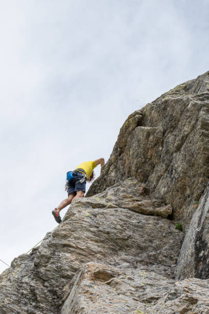 istock Mountain climber ascends rock face 1360225144