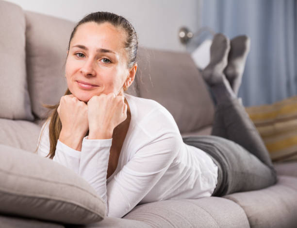 istock Woman lying and posing on couch 1360226165