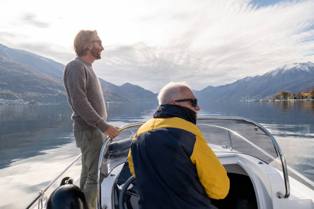 pai e filho em barco piloto desfrutam de lago no outono - nautical vessel motorboat speedboat people - fotografias e filmes do acervo