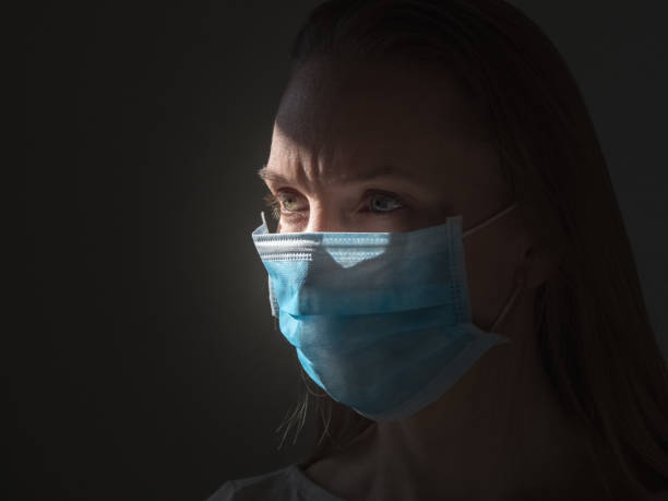 istock A woman putting on a medical disposable mask to avoid contagious viruses 1360226383