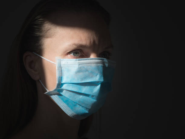 istock A woman putting on a medical disposable mask to avoid contagious viruses 1360226385