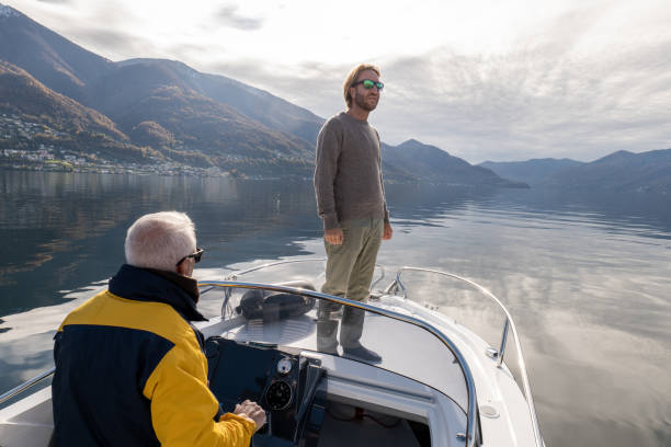 istock Father and son on pilot boat enjoy lake in Autumn 1360226949