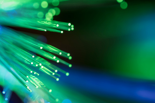 A DSLR close-up photo of fiber optics in green tones. Shallow depth of field, beautiful bokeh. Space for copy.