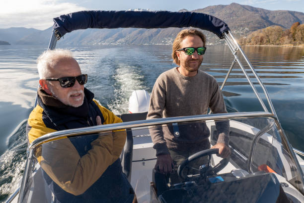 istock Father and son on pilot boat enjoy lake in Autumn 1360228507