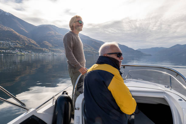 istock Father and son on pilot boat enjoy lake in Autumn 1360228721