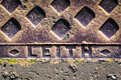 Close-up of a manhole cover in Leith, to the north of central Edinburgh, Scotland.