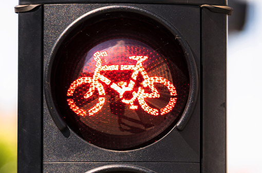Close-up of a bicycle traffic light showing red, advising cyclists to stop.