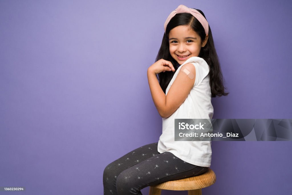Profile of a child after getting a shot Studio portrait of a smiling latin kid feeling brave and happy after getting the covid vaccine Child Stock Photo